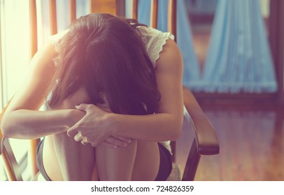 sad woman sitting in room , lonely woman ,heartbroken,thinking about love
