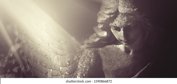 Sad Wonderful Angel In The Rays Of The Sun. Antique Statue.Horizontal Image.