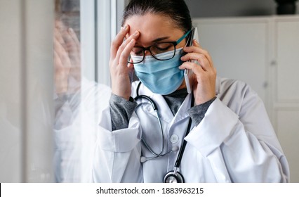 Sad and worried female doctor talking on the phone - Powered by Shutterstock