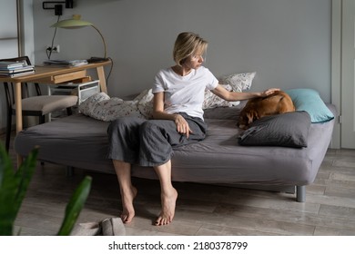 Sad Worried Middle-aged Woman Sitting On Sofa Caring For Old Sick Pet At Home, Saying Goodbye Before Death, Spend Final Day Together, Upset Female Pet Owner Petting Ill Dog Curl Up In Ball In Bed