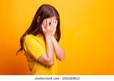 Sad Young Asian  Woman Cry With Palm To Face In Yellow Dress On Yellow Background