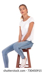 Sad Young Casual Woman Sitting On Chair On White Background