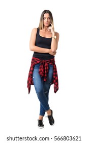 Sad Young Casual Woman In Street Style Clothing Looking Down. Full Body Length Portrait Isolated Over White Studio Background.