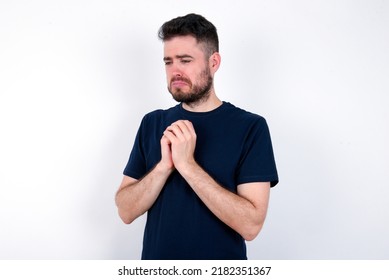 Sad Young caucasian man wearing black T-shirt over white background desperate and depressed with tears on her eyes suffering pain and depression  in sadness facial expression and emotion concept