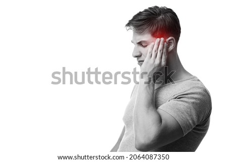 Sad young european guy suffering from headache, press hand to head, monochrome photo and temple highlighted in red, isolated on white background. First signs of illness, migraine, health problems