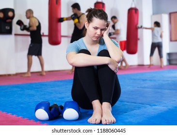 Sad Young Girl Loser Sitting On The Floor In The Boxing Hall