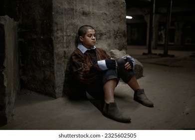 Sad young homeless teenager woman sitting alone outdoors on street - Powered by Shutterstock