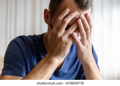 Sad Young Man Holding His Head From Grief And Worries