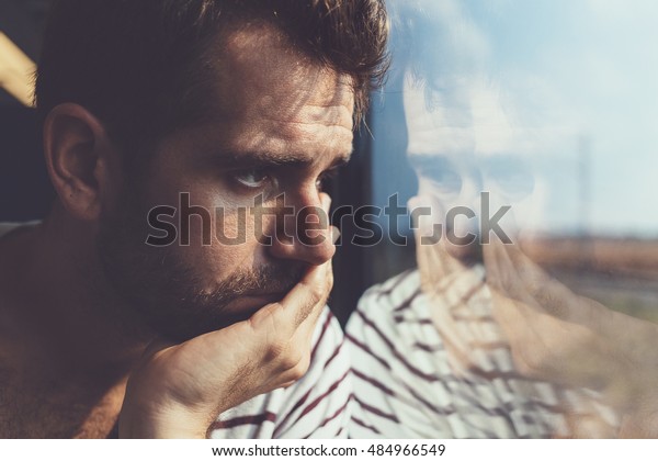 Sad Young Man Looking Through Window Stock Photo (Edit Now) 484966549