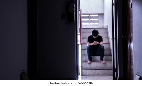 A Sad Young Man Sitting On The Stairs Fire Escape.