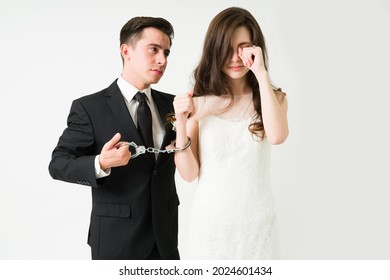 Sad Young Wife Crying On Her Wedding Day While Handcuffed To Her Pleading Caucasian Groom 