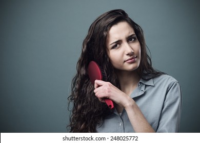 Sad Young Woman Brushing Her Tangled  Frizzy Hair