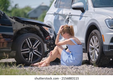 Sad Young Woman Driver Sitting Near Her Smashed Car Looking Shocked On Crashed Vehicles In Road Accident