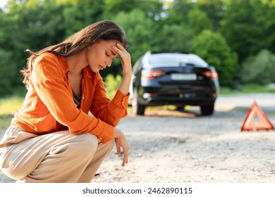 Sad young woman driver sitting on road with broken car on background, upset lady waiting for help, having problems with vehicle - Powered by Shutterstock