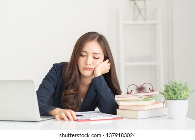 Sad Young woman employee having problems about her debts and financials. Frustrated Asian Beautiful businesswoman feeling depression, exhausted, tired, lazy during working at the office.