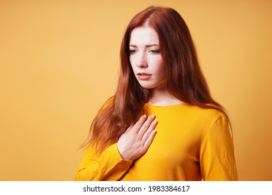 Sad Young Woman With Hand On Chest Feeling Heartache Or Heartburn