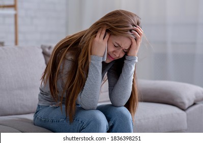 Sad Young Woman Having Conversation On Mobile Phone And Crying At Home. Millennial Lady Having Difficult Talk, Hearing Sad News, Going Through Breakup Or Relationship Problems