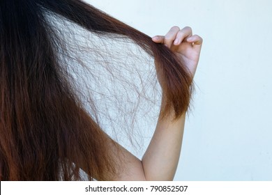 Traurige junge Frauen mit langen Haaren in der Hand, Haarschäden, Gesundheit und Schönheit Konzept.