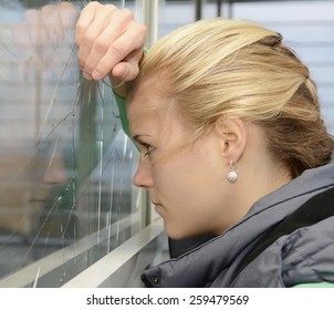 Sad Young Woman Looking Through Broken Window