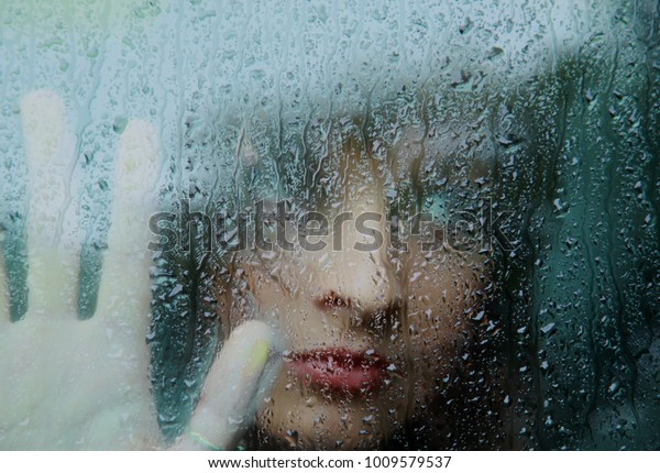 Sad young woman and a rain\
drops.