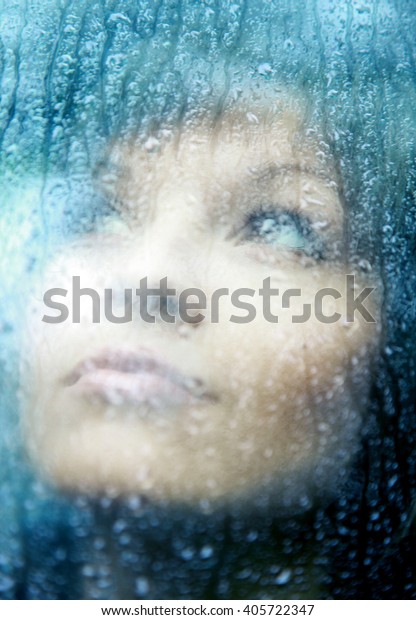 Sad young woman and a rain\
drops 
