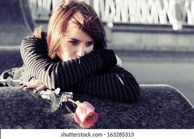 Sad Young Woman With A Red Rose