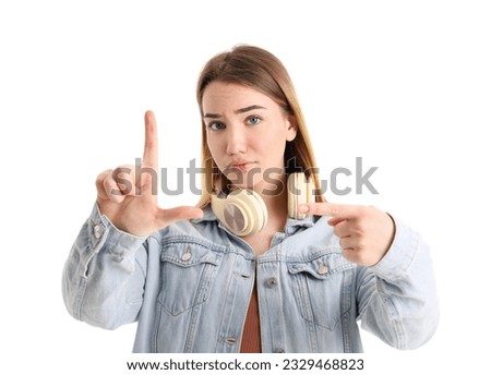 Sad young woman showing loser gesture on white background