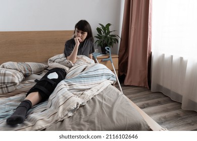 Sad Young Woman Siting In Bed After An ACL Surgery.