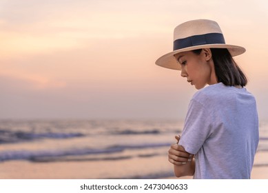 Sadly and depressed asian woman standing with arms crossed on the beach near the sea alone. Bad feelings, through. Loneliness person. Depression Concept. Girl sit alone and think about her.	 - Powered by Shutterstock