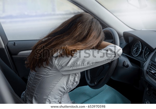 sadness, the driver was stuck in traffic. 
beautiful young woman frustrated in her car. driver fell asleep at
the wheel. what to do in case of an
accident?
