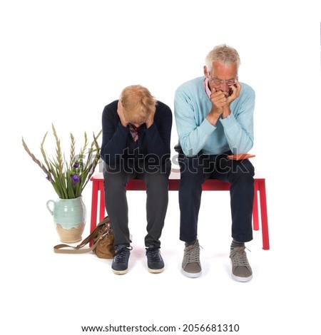 Sadness senior couple in waiting room isolated over white background