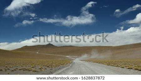 Safari car moving fast in the dust, crossing the bolivian andes