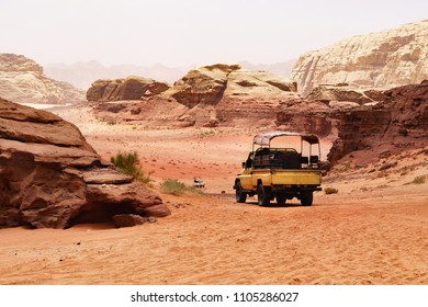 Safari jeep car in Wadi Rum desert, Jordan, Middle East, known as The Valley of the Moon. Red sands, sky with haze. Designation as a UNESCO World Heritage Site. Retro effect. - Shutterstock ID 1105286027