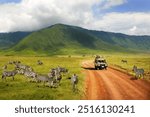 Safari in Ngorongoro Crater National park. Zebras against mountains and clouds.  Tanzania. Wild nature of Africa. 