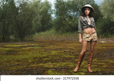 Safari Woman In Swamp Wearing Safari Hat Standing On Moss