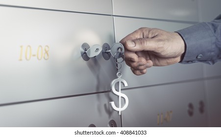 Safe deposit in a bank vault, hand about to turn a key to open a safe box. Financial concept 