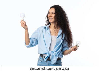 Safe Lightbulb Disposal. Cheerful Woman Holding Used Light Bulbs Standing Over White Studio Background. Waste Sorting, And Energy Saving Light-Bulb Disposal Service Concept