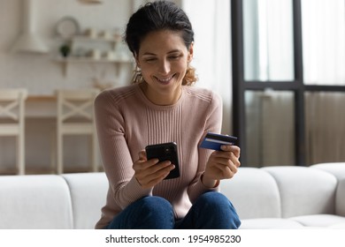 Safe Mobile Banking. Smiling Latina Lady Client Hold Mobile Phone Credit Bank Card Do Online Shopping Provide Internet Payment. Happy Young Woman Enjoy Easy Fast Secure Transferring Money In Ebank App