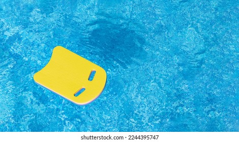 Safe pool training aid float foam board tool. Yellow Swimming kickboard on blue water surface of swim pool. Mockup, Panoramic banner, copy space for text or design. Water sport, active lifestyle - Powered by Shutterstock