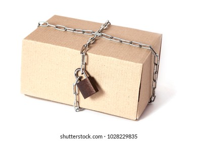 Safe Reliable Delivery Of Cargo In Safety Without Theft. The Cardboard Box Is Wrapped In A Chain With A Closed Lock. Isolated On White Background