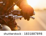 Safe ride concept. Macro left hand of motorcyclist wearing riding glove on the clutch. Outdoor shooting on the road with copy space