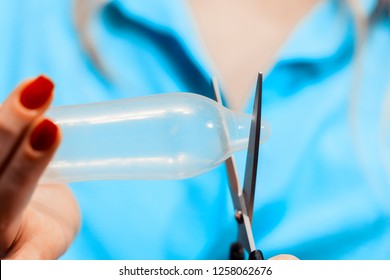 Safe sex concept. Girl cuting condom. damaged