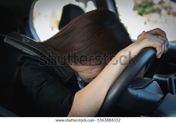 Safe
travel concept : Women are tired and stressed during driving, want
to stop by sleeping behind the steering
wheel.
