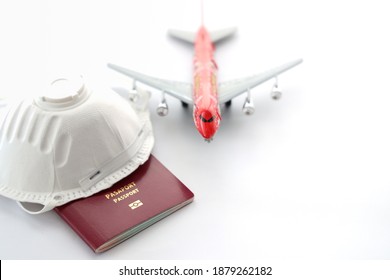 Safe Travel During The Virus Covid-19 Pandemic. Airplane Model With Face Mask, Passport, Isolated On White Background, Top View, No People, Copy Space For Text. 