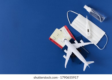 Safe travel during virus. Passport and boarding pass with surgical mask, alcohol antiseptic gel and thermometer on blue background top view. Protectiv accessories from virus during traveling. - Shutterstock ID 1790655917