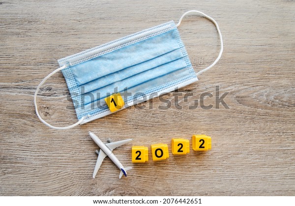 Safe\
travels concept 2022. Plane with surgical medical mask. Safety\
flight and travel during quarantine and\
lockdown.