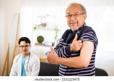 Safe Vaccination For Old People. Elder Man In Medical  Getting Flu Or Covid-19 Vaccine Sitting On Sofa At Home. Asian Doctor Or Nurse Giving Flu Or Covid-19 Shot To Senior.