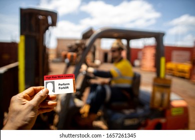 Safe Workplace Clear Image Of Forklift Licence Card With Defocused Forklift Driver Operator Wearing Work Uniform Safety Seat Belt Working Mechanical Lifting Delivery Material At The Background  