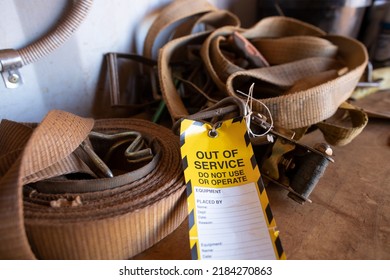 Safe workplaces practices yellow out of service warning tag sign placing on damaged faulty unsafe to use truck tie down strap load restraint ratchet webbing   - Shutterstock ID 2184270863