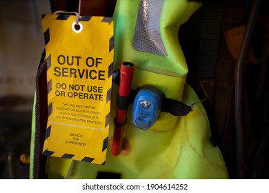 Safe workplaces yellow out of service tag warning sign hanging on damage faulty placing on boat marine safety personal floatation device equipment  